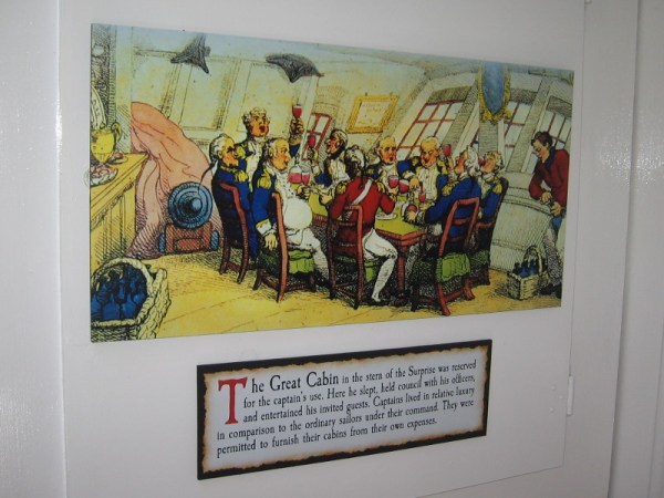 Sign reads the Great Cabin in the stern of the Surprise was reserved for the captain's use. Here he slept, held council with his officers, and entertained his invited guests.