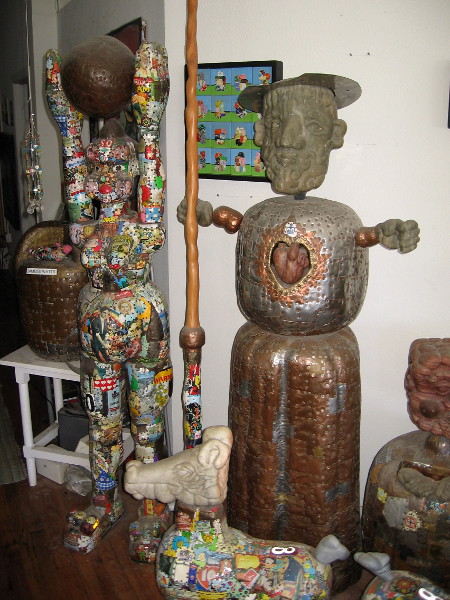 On the left a female Atlas holds up the world. To the right Don Quixote appears ready to tilt at windmills.