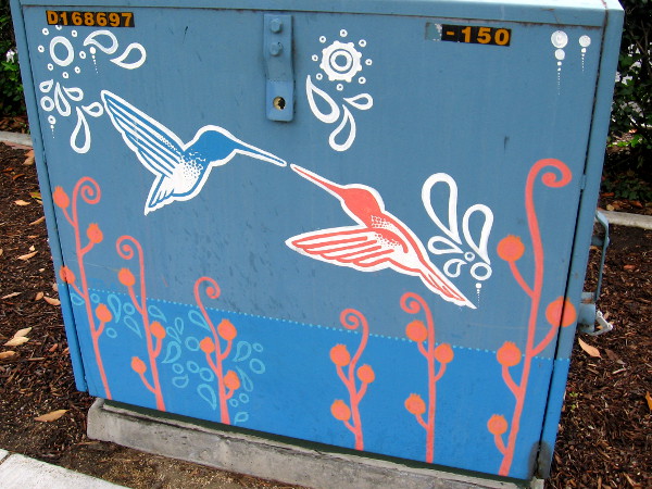 Two hummingbirds touch beaks.
