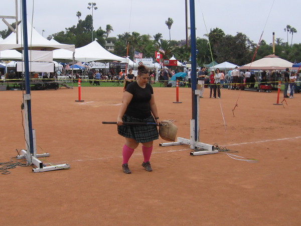 A female contestant readies to toss the sheaf with a pitchfork.