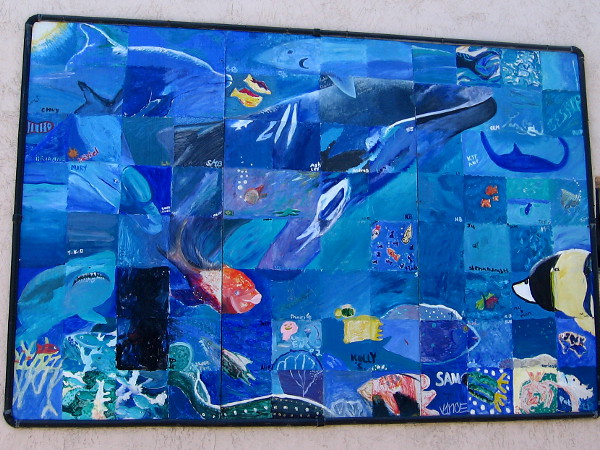 A whale, shark, dolphin, ray and other sea life painted on a community mural in Ocean Beach.