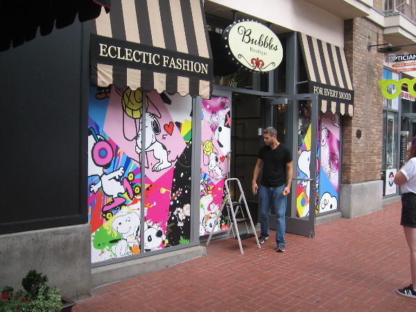 Snoopy graphics on the windows of Bubbles Boutique transform it into the Peanuts Pop-Up Shop!