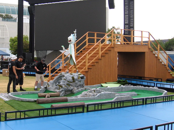 Rick sculpture stands over a miniature golf hole.