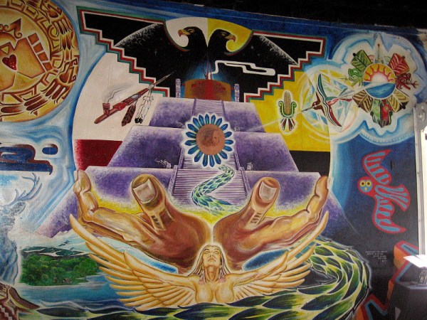 Quetzalcoatl, feathered serpent, wise creator of humankind, moves through the mural and finally faces the viewer from the center of a pyramid, amid symbols of life and light.