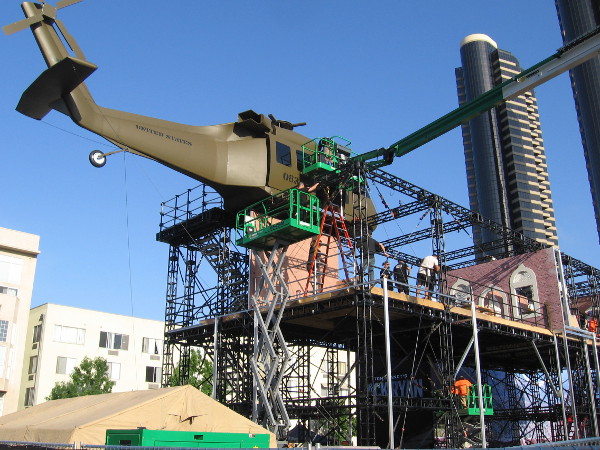 Guys work on the helicopter which seems to have a fresh coat of glossy paint.