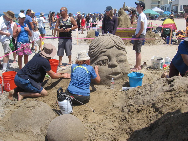 Sandytales was creating Dreaming, an imaginative sand sculpture with another sleepy face and whimsical castle.