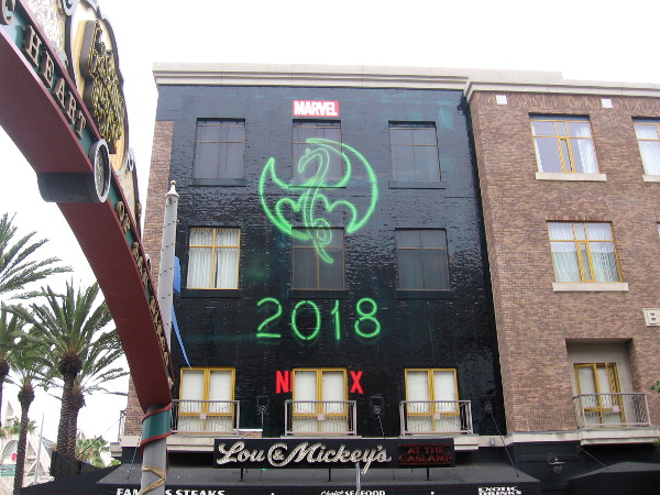 The symbol for Marvel hero Iron Fist in a building wrap near the Gaslamp Quarter landmark sign.