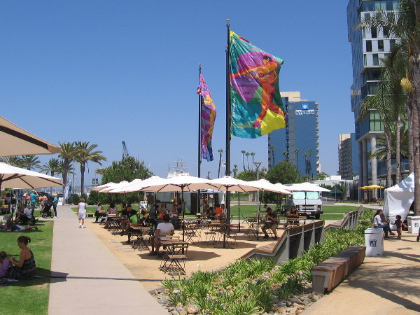 The baseball windglyphs of local artist Lisa Schirmer fly above diners under umbrellas at Lane Field Park.