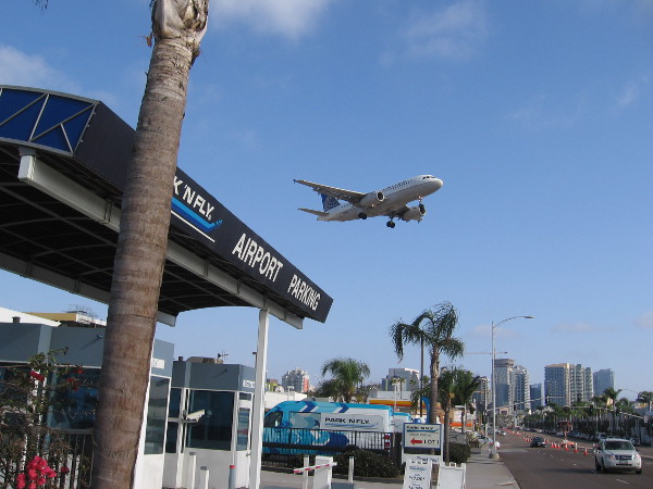 An airplane comes in for a landing at San Diego International Airport near the intersection of Pacific Highway and Laurel Street.