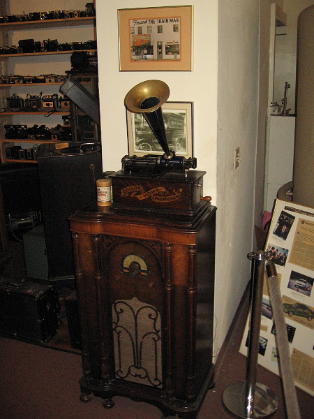 An old photo of the Frank The Train Man storefront over an Edison Home Phonograph.