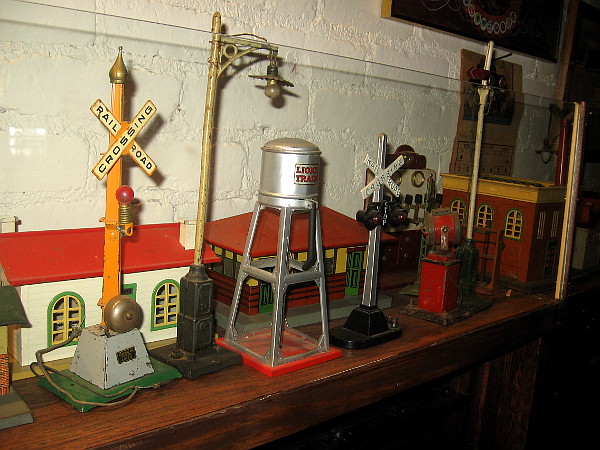 Lionel toy train accessories including buildings and railroad crossing signals.