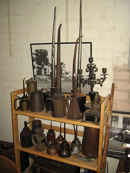 A bunch of old-fashioned oil cans and various other objects.