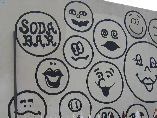 Fun emoji-like faces on the wall of the Soda Bar in City Heights.