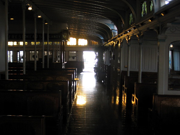Splashes of sunlight reflect from the floor, woodwork and empty benches inside the passenger deck of Berkeley.