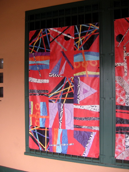 A banner showing a contemporary quilt outside Visions Art Museum at Liberty Station.