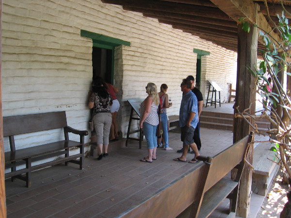 Visitors to Old Town San Diego State Historic Park look into a restored room of La Casa de Estudillo.