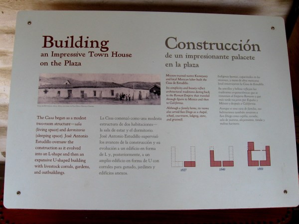Sign describes how the casa started as a modest two-room structure and eventually grew into an expansive U-shaped building with a courtyard and outbuildings.