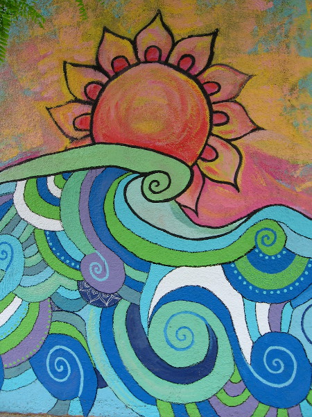 A beautiful sun shines above stylized waves.