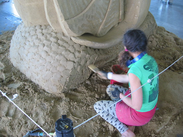 Meg Murray concentrates on her poetic sand art.