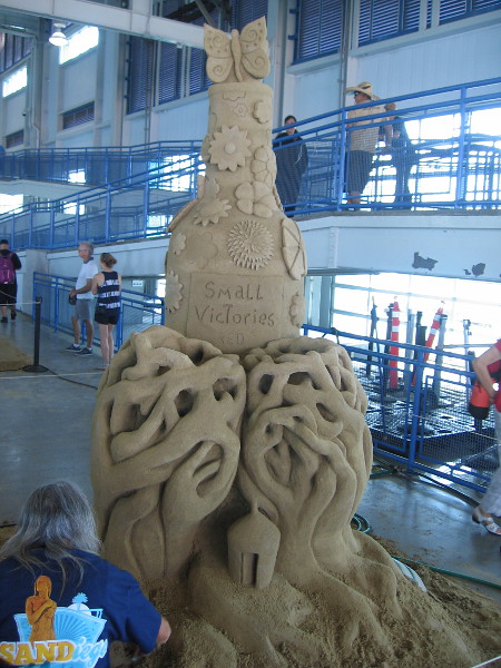 Small Victories, a happy sand sculpture by World Master Lucinda "Sandy Feet" Wierenga from South Padre Island, Texas.