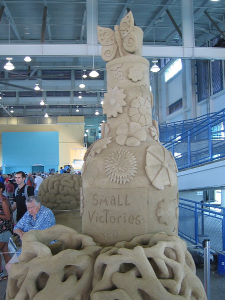 A butterfly emerges from a flowery bottle of small victories.