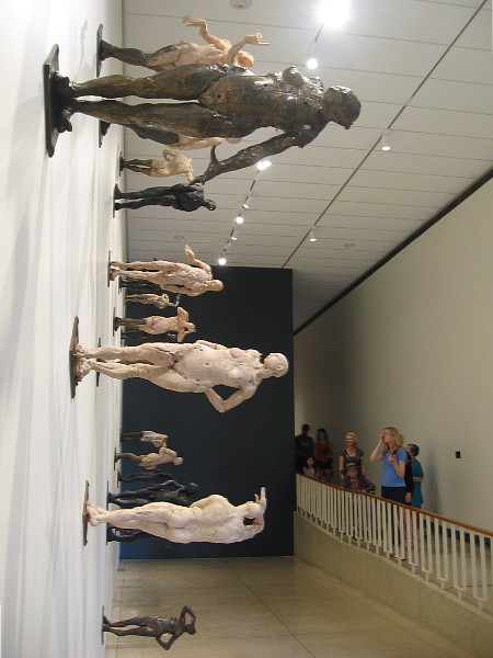 Visitors to the San Diego Museum of Art enter Gallery 15, where many human figures sculpted by Mexican artist Javier Marín stand horizontally upon a large wall.