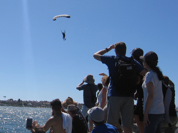Here comes another contestant. Helicopters took parachutists high above the water, and the crowd shielded their eyes from the sun to see them descending.