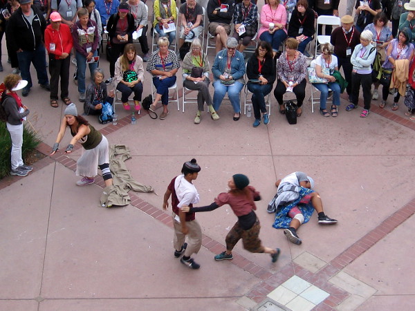 Dancers converge in front of the audience. The dance portrays different people who are homeless.
