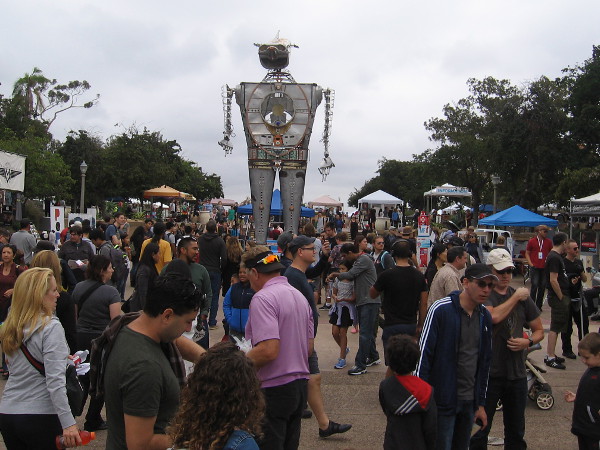 A big crowd surrounds 30-foot-tall, flame throwing Robot Resurrection during 2018 Maker Faire San Diego in Balboa Park.