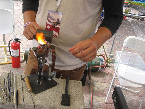 This guy was melting glass and forming a beautiful jewelry pendant.
