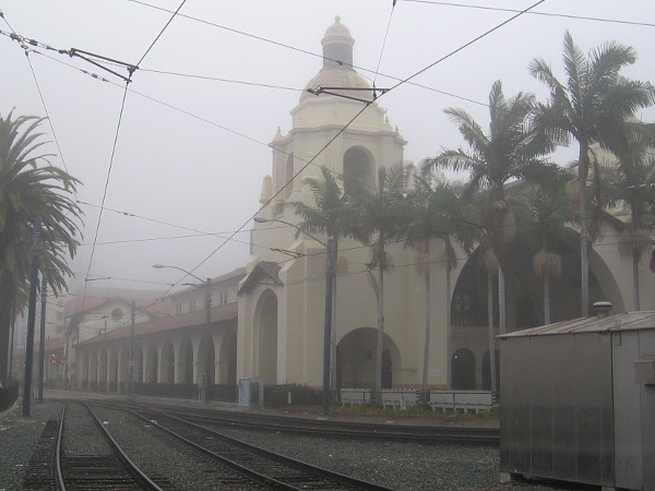 Trolley tracks lead through a fog past Santa Fe Depot in San Diego.