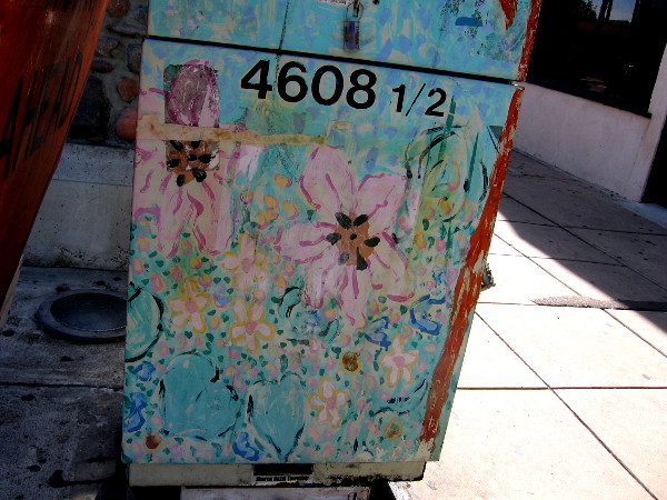 Faded flowery street art on a utility box.