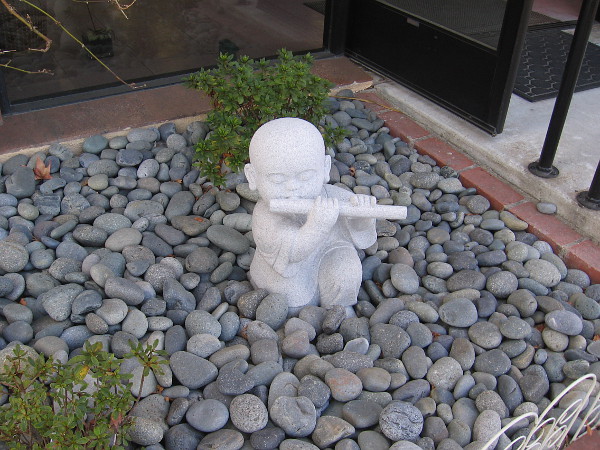 A small, peaceful sculpture in front of Buddha's Light Bookstore.