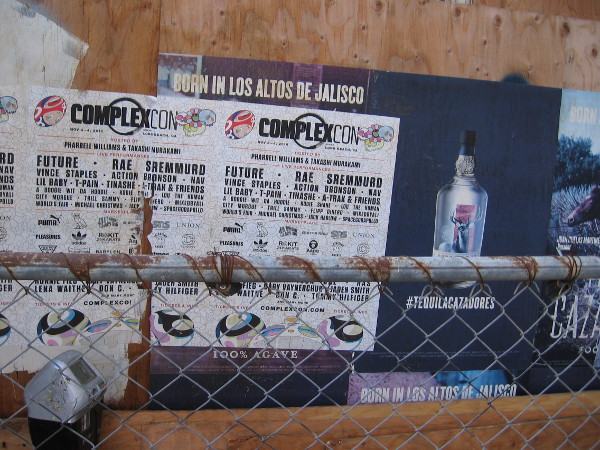 Advertisements peeling from a construction site fence.