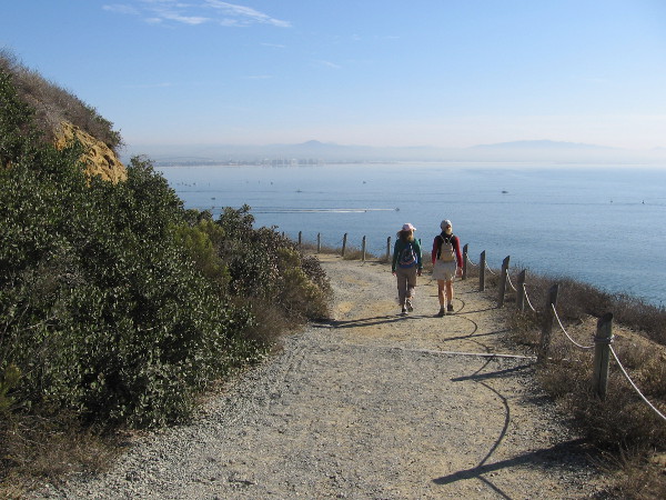 People walk down Cabrillo National Monument's Bayside Trail in order to watch a bit of sailing history.