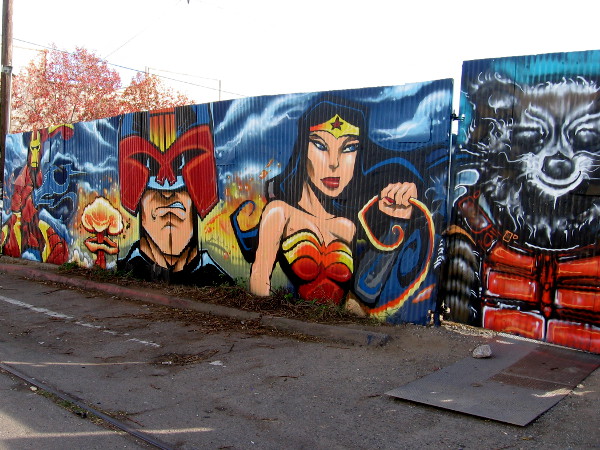 Cool comic book superheroes, villains and other characters are spray painted on a long wall in Logan Heights!