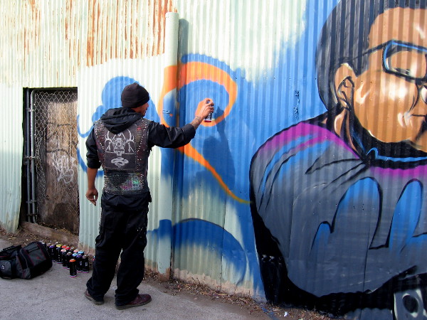 Fizix at work on a new commissioned mural featuring superheroes, supervillains and a few other characters.