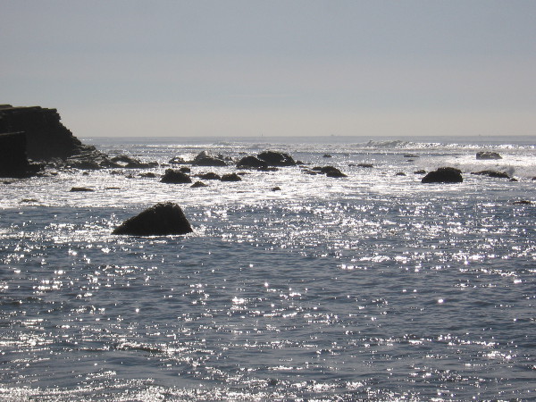 Looking south at light on the water and dark, broken rocks.