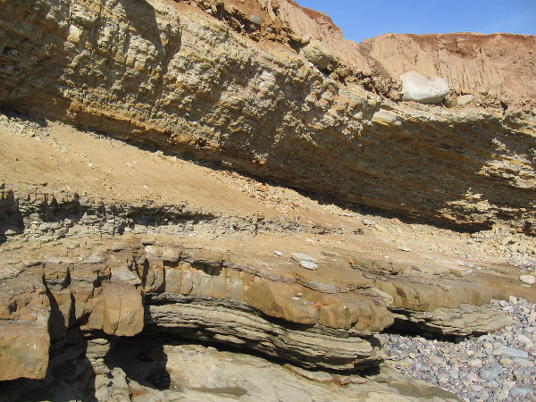 Little piles of sand and stone collect where the cliffs crumble.