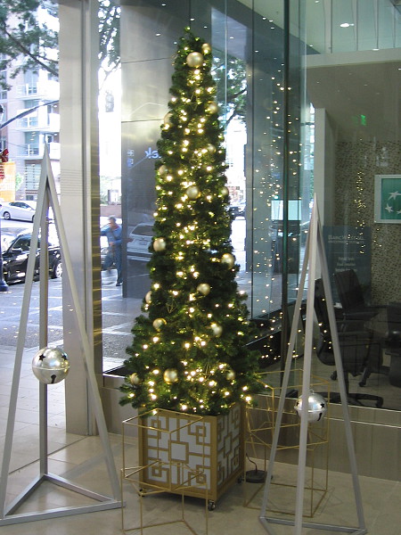 One of the slender Christmas trees adding holiday cheer to the north entrance to the 701 B Street office building.