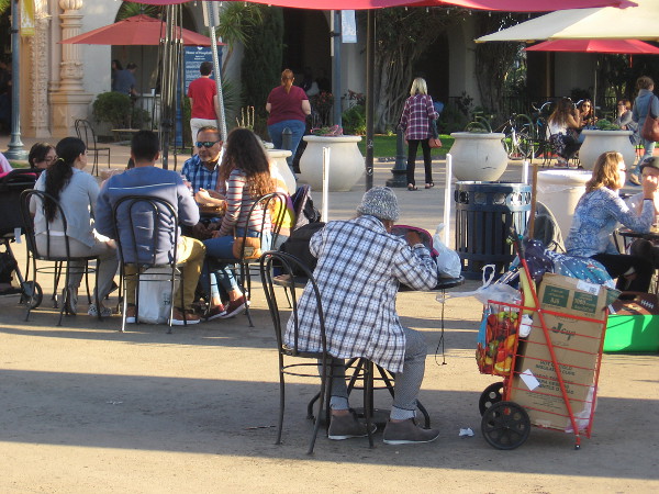 People eat, talk, relax at tables in the Plaza de Panama.