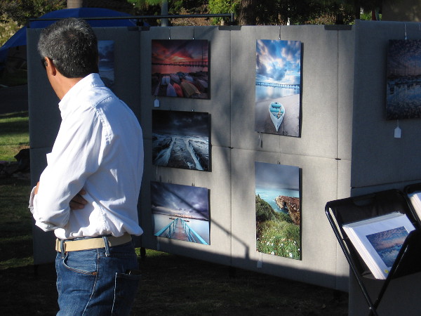 Perusing photographs by a local artist at Art in the Park.