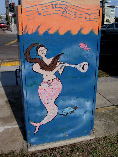 A happy mermaid plays an underwater horn!