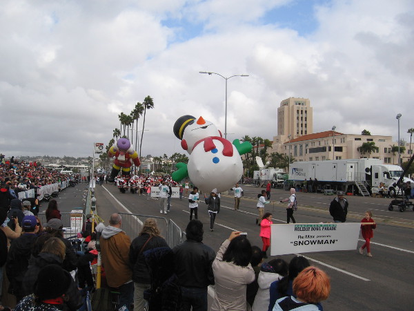 Snowman is either tipping backward in the breezy weather or gradually melting.