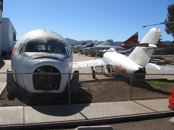 Cockpit exhibits and aircraft in various stages of restoration stand outside the museum annex hangar.