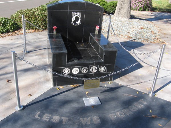 To one side stands the POW/MIA Empty Chair. And the words: Lest We Forget.