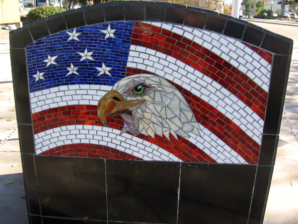 American eagle and flag mosaic art on rear of the POW/MIA Empty Chair is by the Rainforest Art Project.