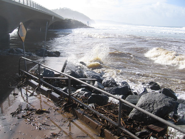 Ocean waves crash toward the North Torrey Pines Road bridge over the entrance to Los Peñasquitos Lagoon.