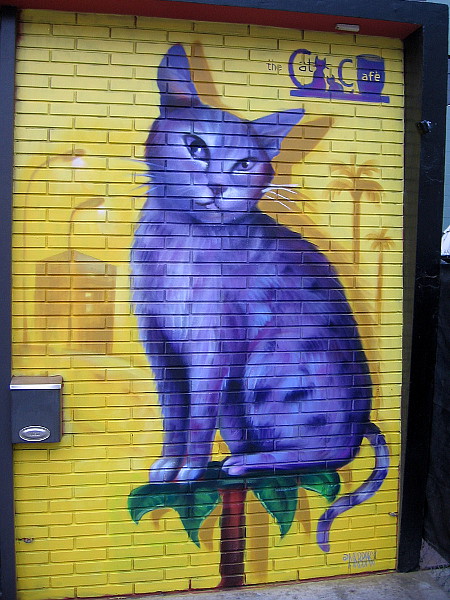 A purple cat on the wall of The Cat Cafe.