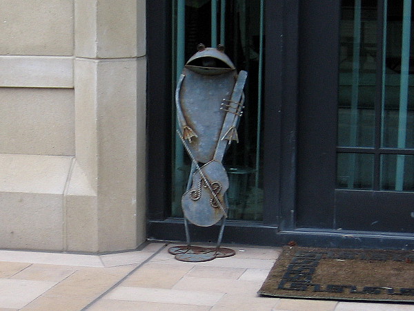 A frog plays the violin by somebody's front door!